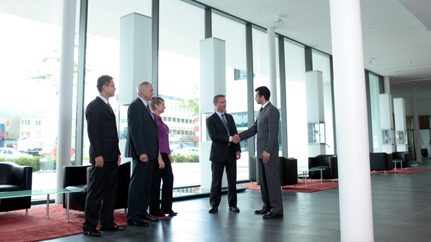 Mitarbeiter und Kunde beim Händeschütteln in der Lobby von Endress+Hauser
