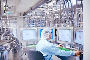 Pharmaceutical company employee monitors real-time manufacturing data