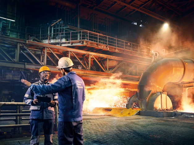 Zwei Ingenieure unterhalten sich in einer Metallfabrik.
